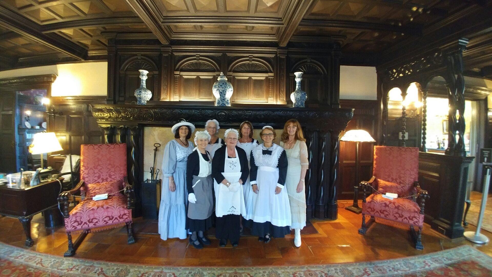 Image of seven docents dressed as maids at the Bayard Cutting Arboretum Manor House.